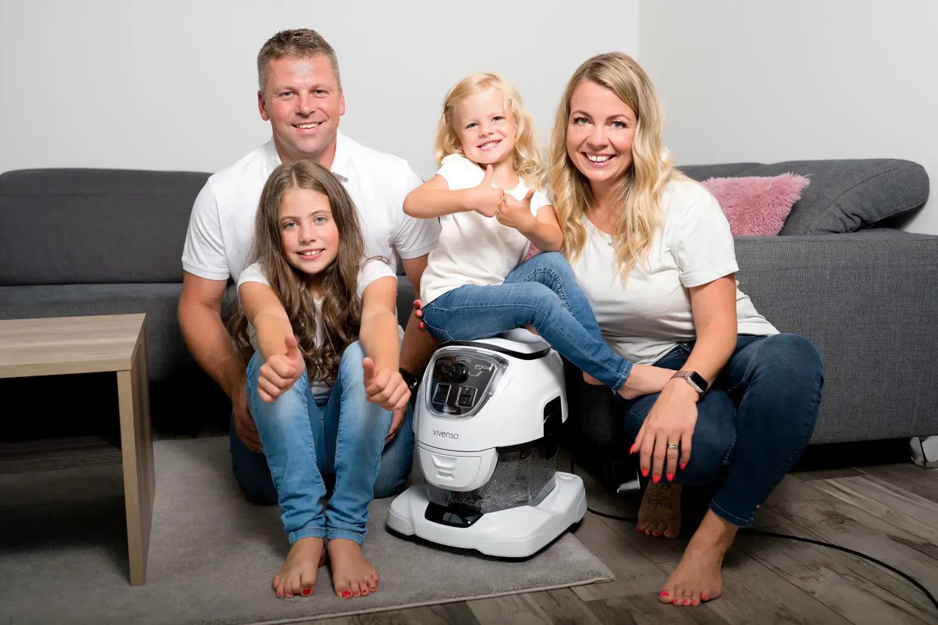 Familie mit dem Wasserstaubsauger nach der Teppichreinigung