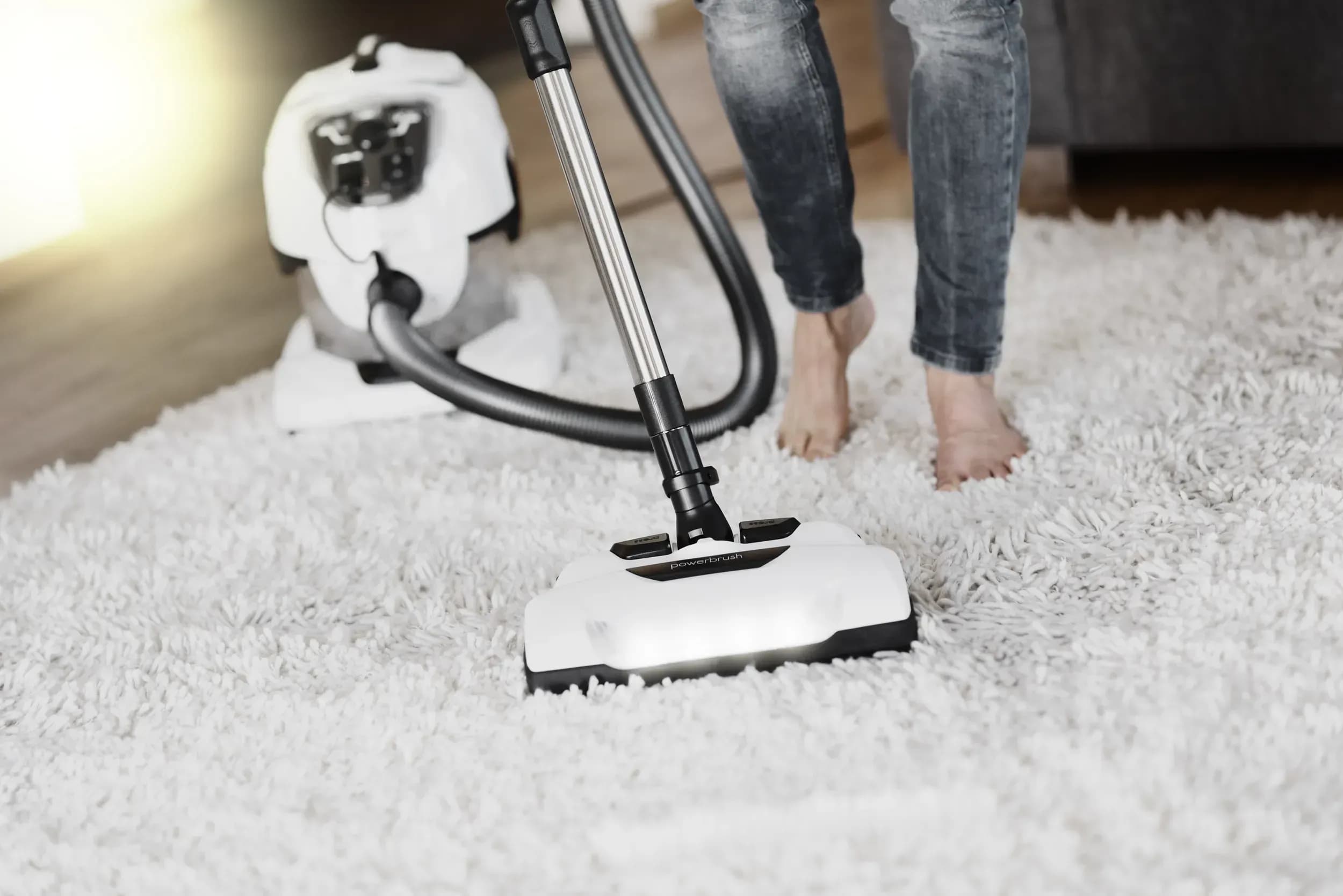 Mit einem Wasserstaubsauger wird der Teppich gesaugt