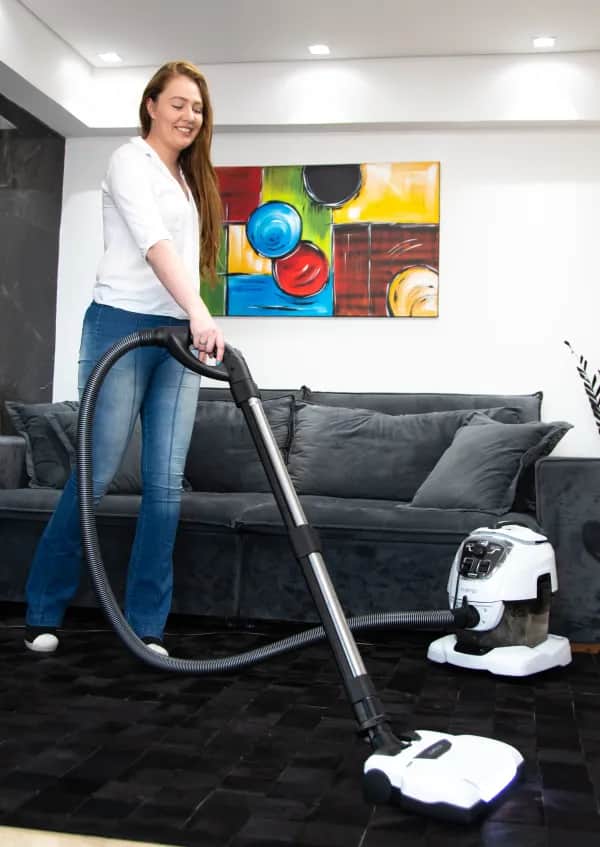 Frau saugt mit Vivenso den Teppich