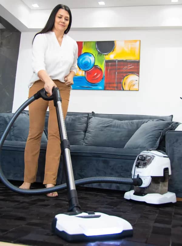 Frau saugt Teppich mit dem Vivenso Staubsauger